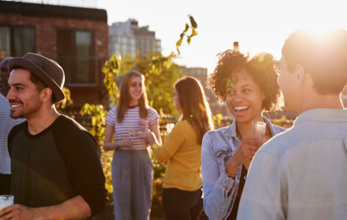 Jovens em terraço ensolarado conversando felizes